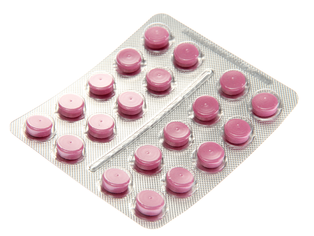 Pink pills blister packed on white background